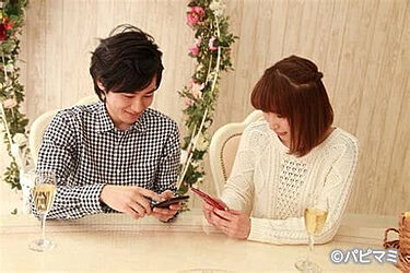スマフォを確認し合うカップル