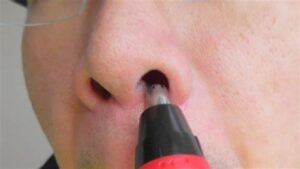 鼻毛カッター使用中男性